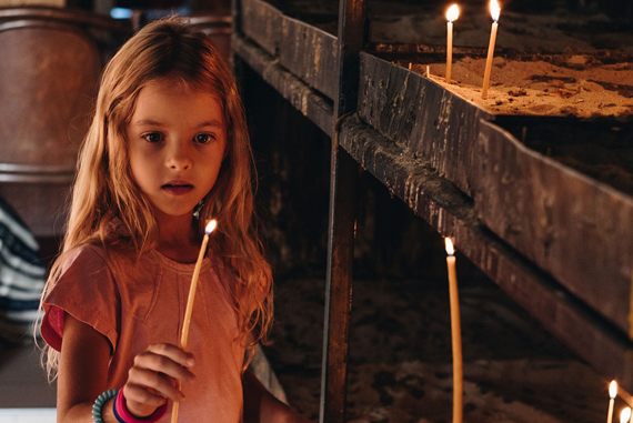 Girl lighting candles in a dim space.