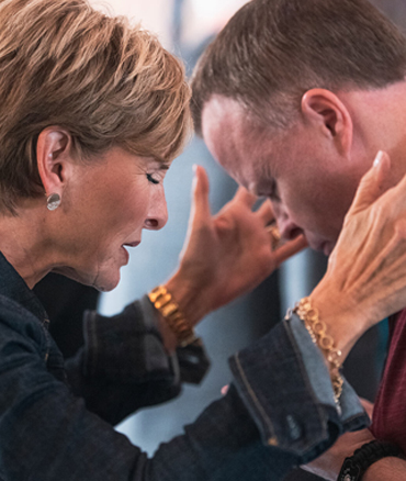 Woman with short hair comforting a man.