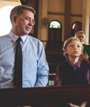 Man and boy sitting in a church.