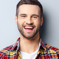 Smiling man wearing a plaid shirt.