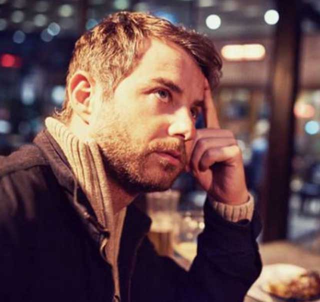 Man thoughtfully resting hand on his face.