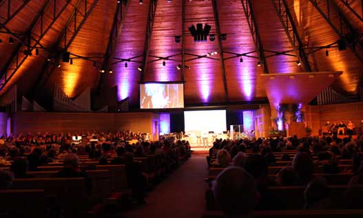 Crowded church interior with colorful lighting.