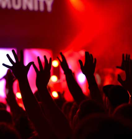Hands raised in concert atmosphere.