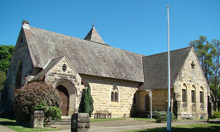 Historic stone church under clear blue sky.