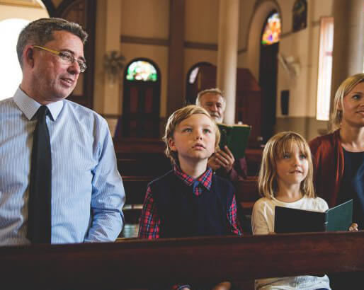 Family sitting in a church, listening attentively.